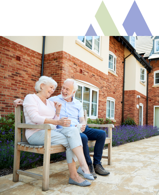 Elderly couple enjoying outdoor seating at the Mira Vie at Brick senior living community.