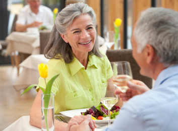 Senior couple indulging in delightful conversation over wine at our retirement community dining area.