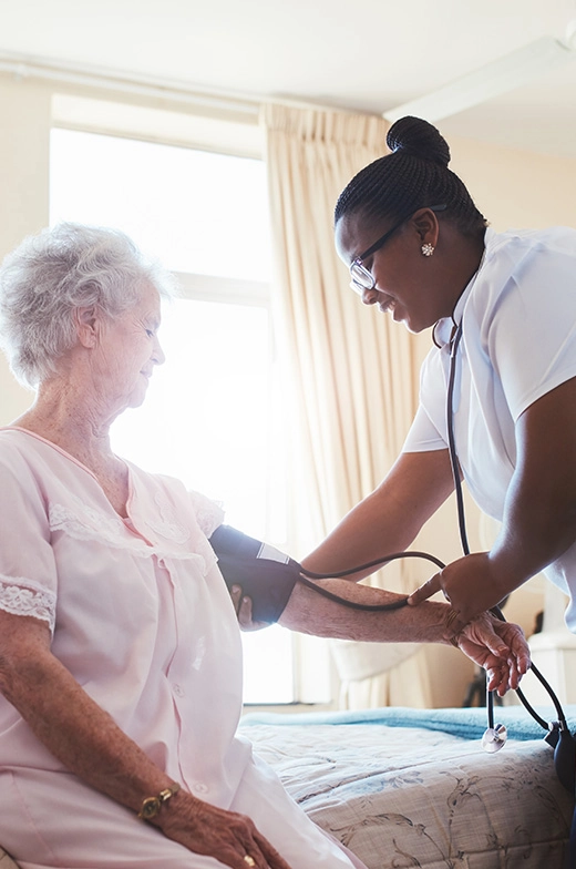 In our retirement community's sunny assisted living space, a nurse meticulously monitors the blood pressure of a senior woman.