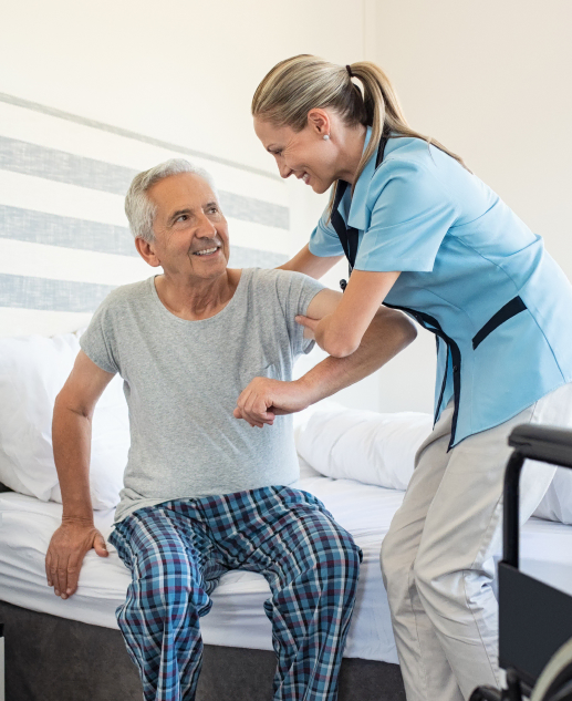 At Mira Vie at Green Knoll, a dedicated healthcare worker is seen helping a cheerful senior resident in his room.