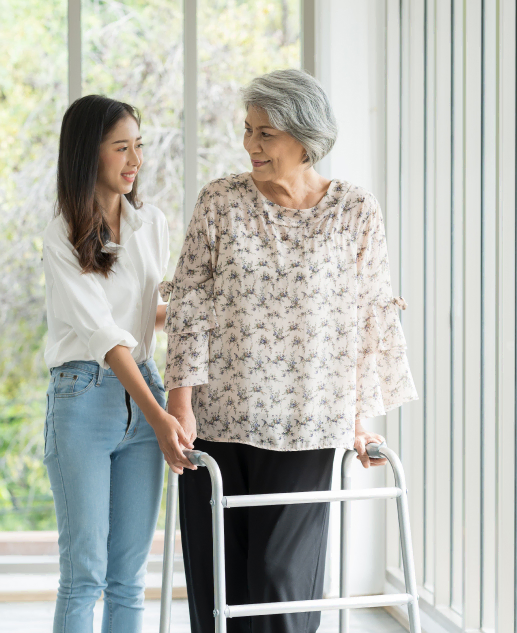 A compassionate caregiver aids a senior resident utilizing her walker at Mira Vie at Brookfield, an exceptional retirement community.