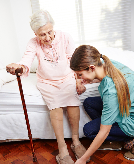 At Clifton's Mira Vie Retirement Community, our caregivers proficiently assist elderly residents with mobility, such as helping them stand up and use a walking cane.