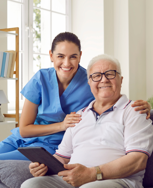 The gentle care of a dedicated healthcare professional using modern technology during your stay at Mira Vie at Fanwood, a comfortable retirement community. We prioritize the well-being and comfort of our elderly residents like this cozy gentleman in glasses relaxing on our couch with his health associate.