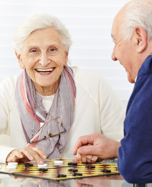 Two seniors at the Mira Vie Manalapan Retirement Community relish a friendly game of checkers.