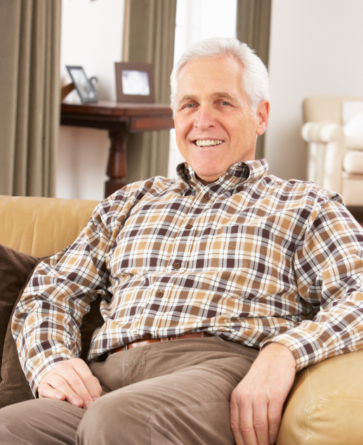 Elderly gentleman happily seated on a cozy couch at the Mira Vie at Montville senior living community.