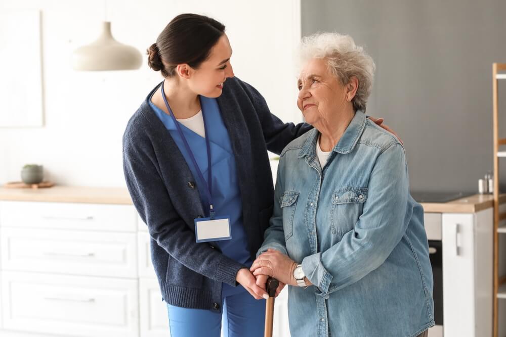 Nurse assists older woman in senior living community