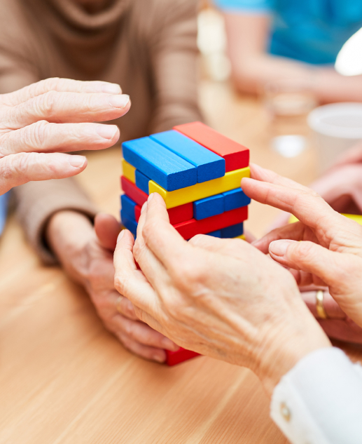 Several seniors at the Mira Vie retirement community in Toms River are joyfully working together on a vibrant block puzzle.