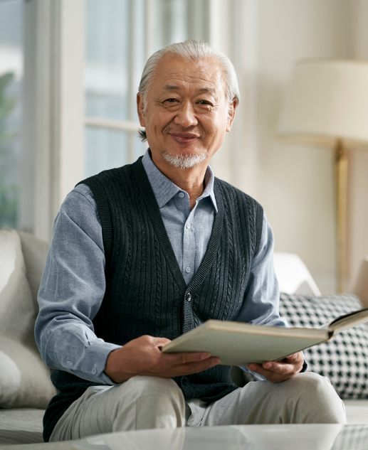 Cheerful senior man enjoys a book in the bright living room at Mira Vie retirement community in Toms River.