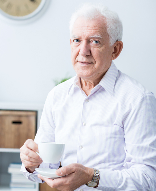 At Mira Vie Retirement Community in Toms River, a content senior gentleman enjoys his coffee, radiating tranquility in his crisp white shirt.