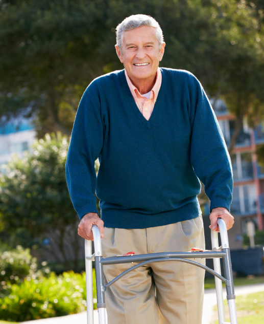 Cheerful senior gentleman enjoys outdoor stroll with assistance from a walker at Mira Vie at Warren - A vibrant retirement home community.