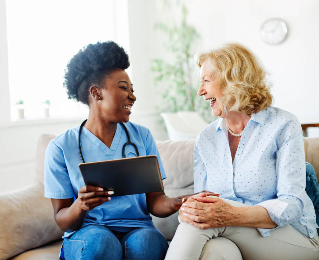A respite provider showing a tablet to a patient