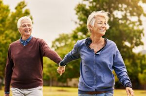 A senior couple wearing comfortable clothing layers while on a walk outside 