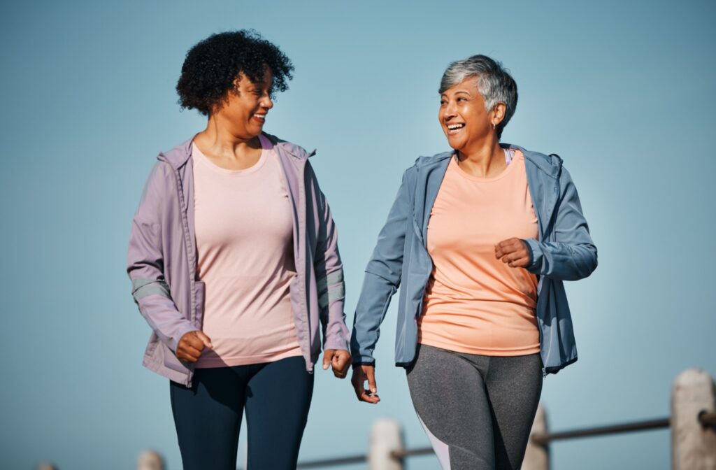 A pair of senior friends enjoying a walk outside together to improve their cardio health