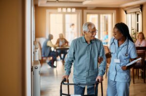 A senior being assisted by a caregiver with daily activities in an assisted living community