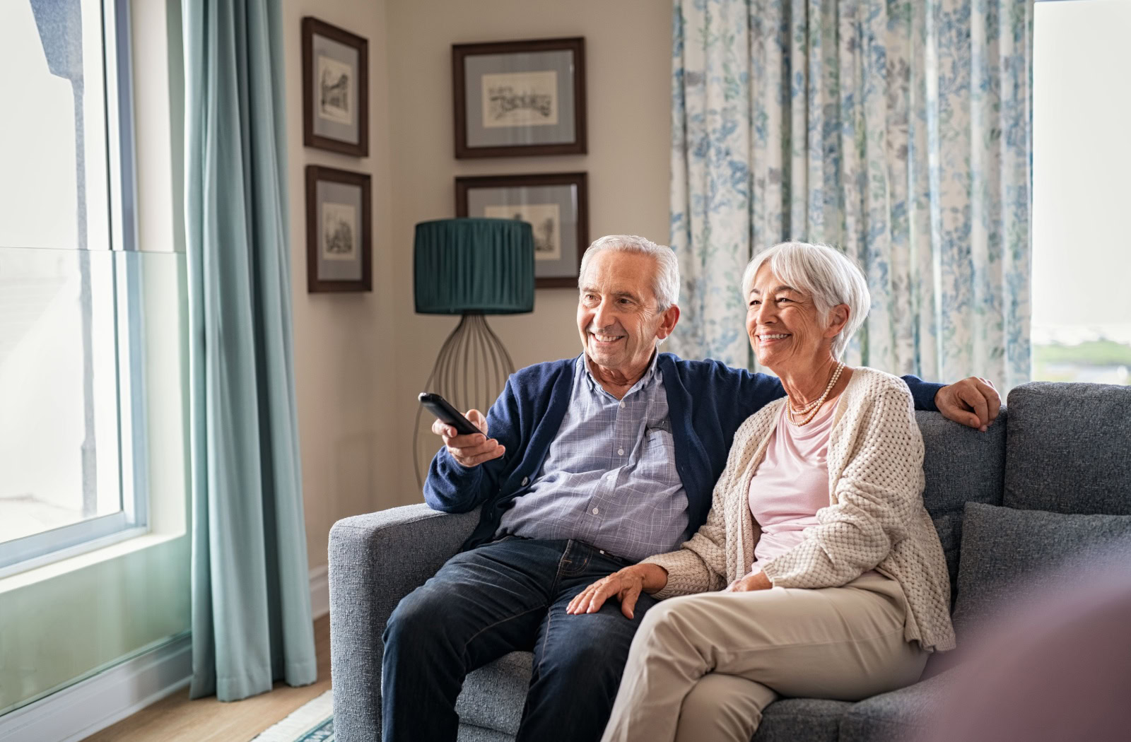 A happy senior couple enjoys watching a movie together.