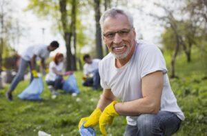 A senior takes part in a community clean-up event.
