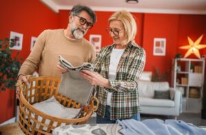 An older couple works together to fold their laundry.