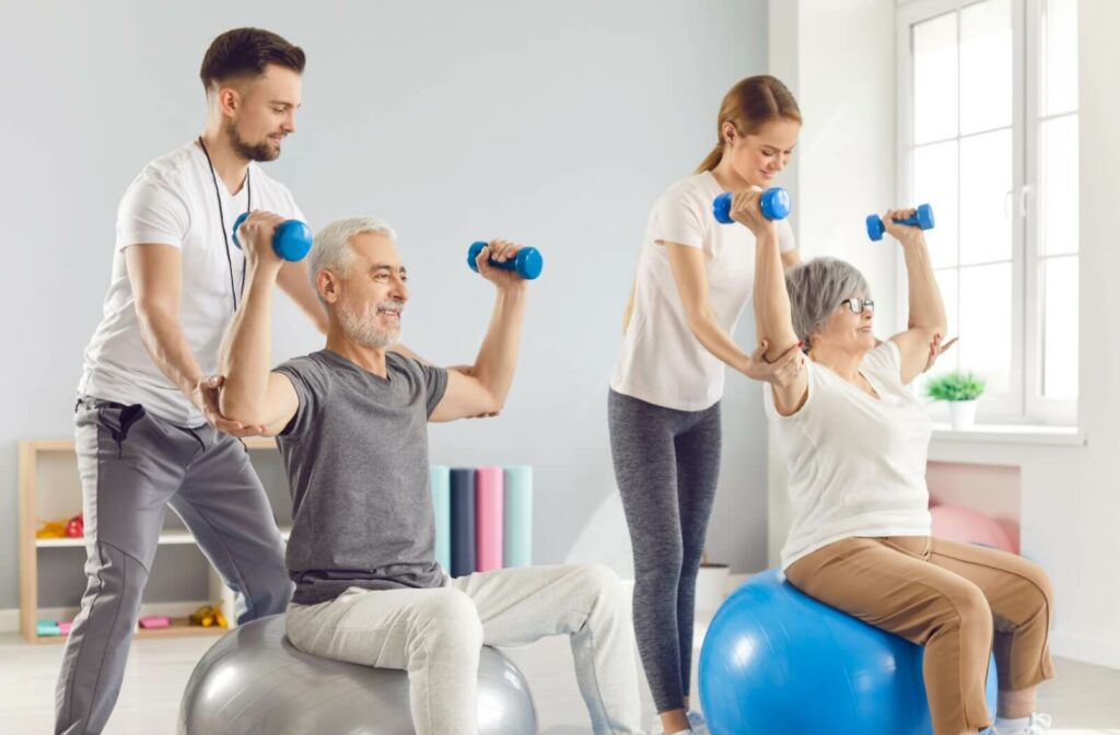 Two seniors are being led in exercises with weights.