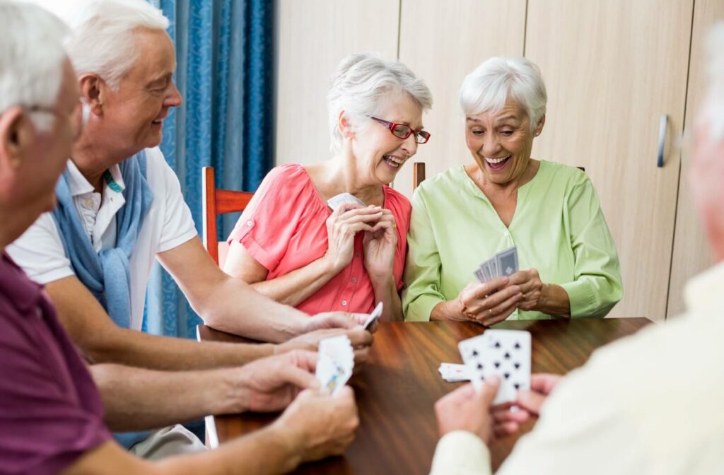 Older adults in an assisted living community enjoying a lively card game together in a warm and engaging environment