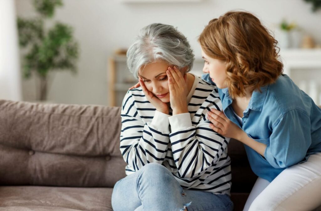 A concerned adult attempts to comfort a senior parent with dementia having a bad day