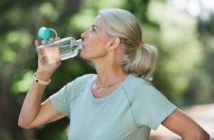 A senior staying hydrated during a game of pickleball