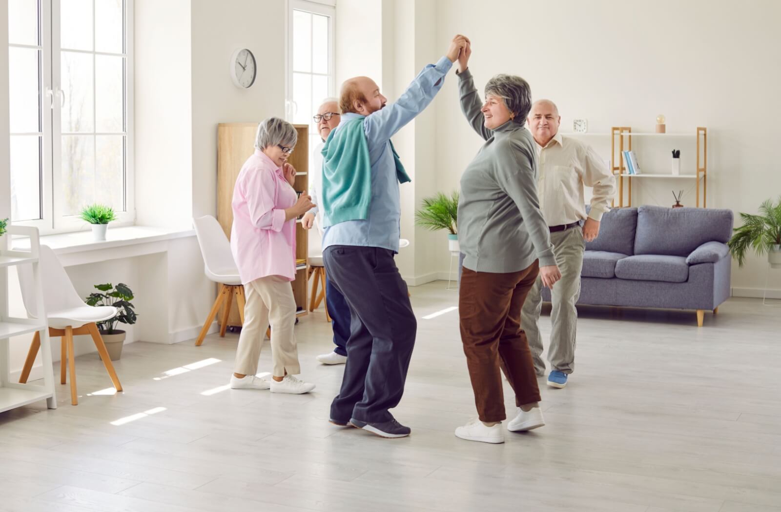 A happy group of senior dancing in their community's common area.