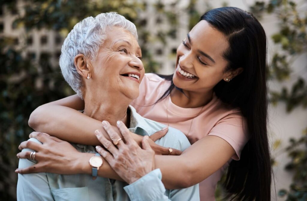 An adult child happily embraces their mature parent.