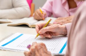 A group of seniors work together to complete a challenging word search.