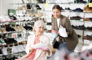 An older adult and their adult child shopping together for comfortable and supportive shoes.
