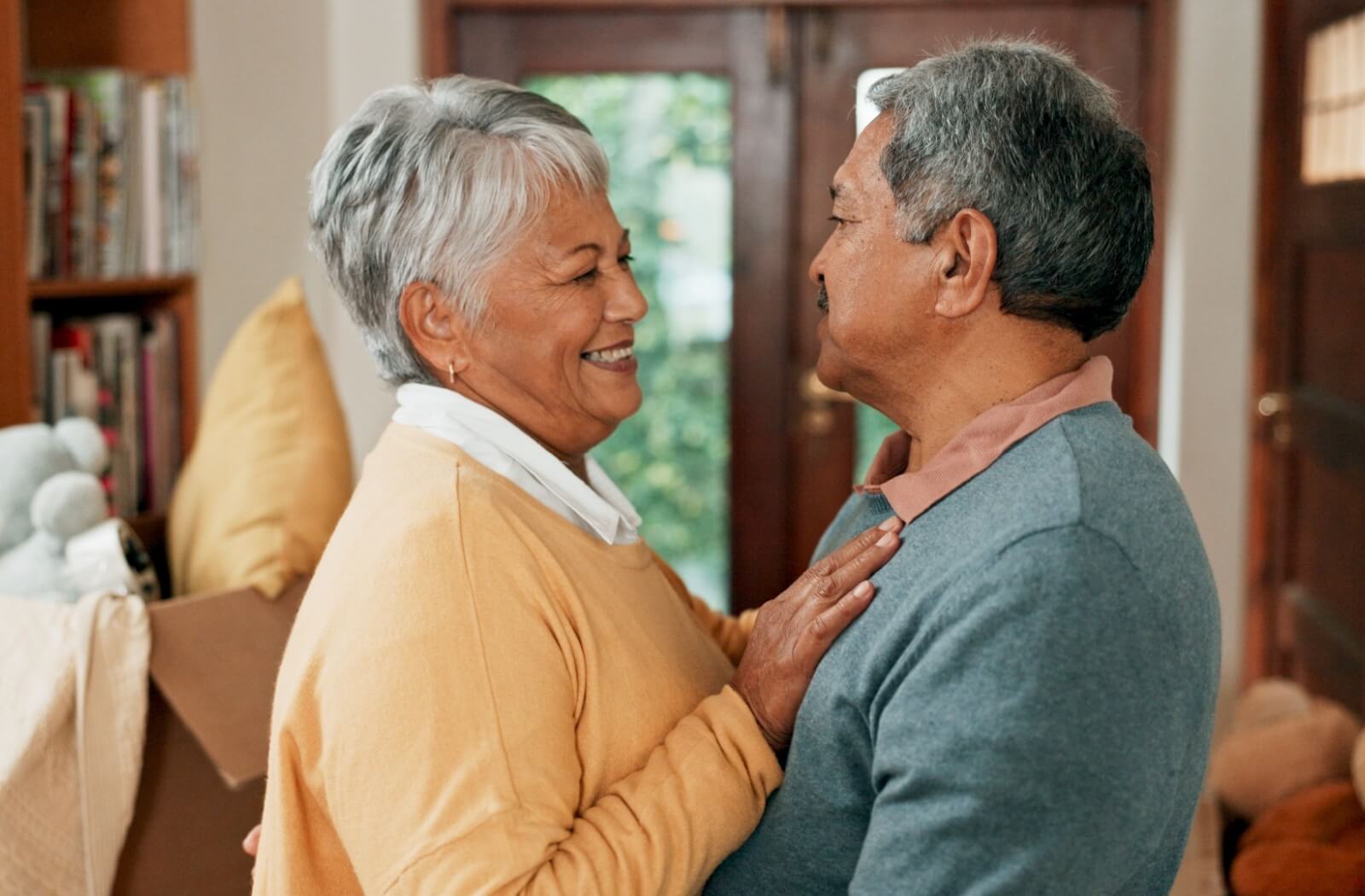 A senior couple embraces lovingly as they prepare to downsize their home.