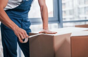 A professional mover helps with packing and securing boxes on the day of the move.