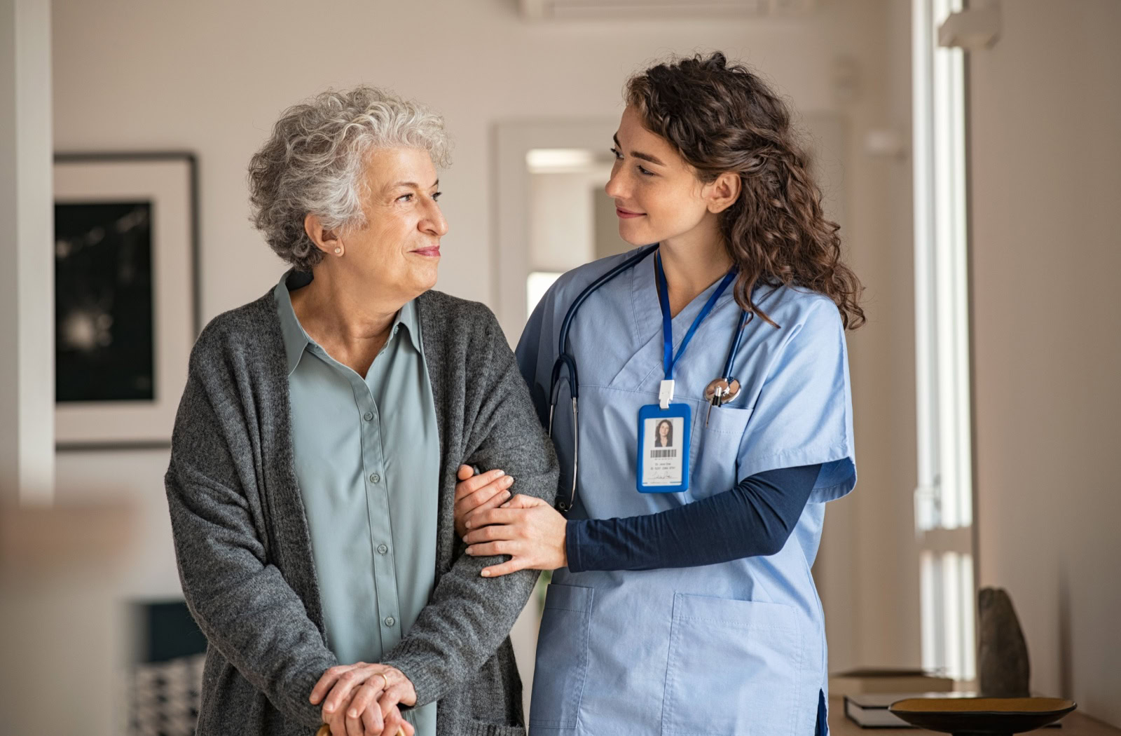 A senior walking with a nurse at a skilled nursing facility