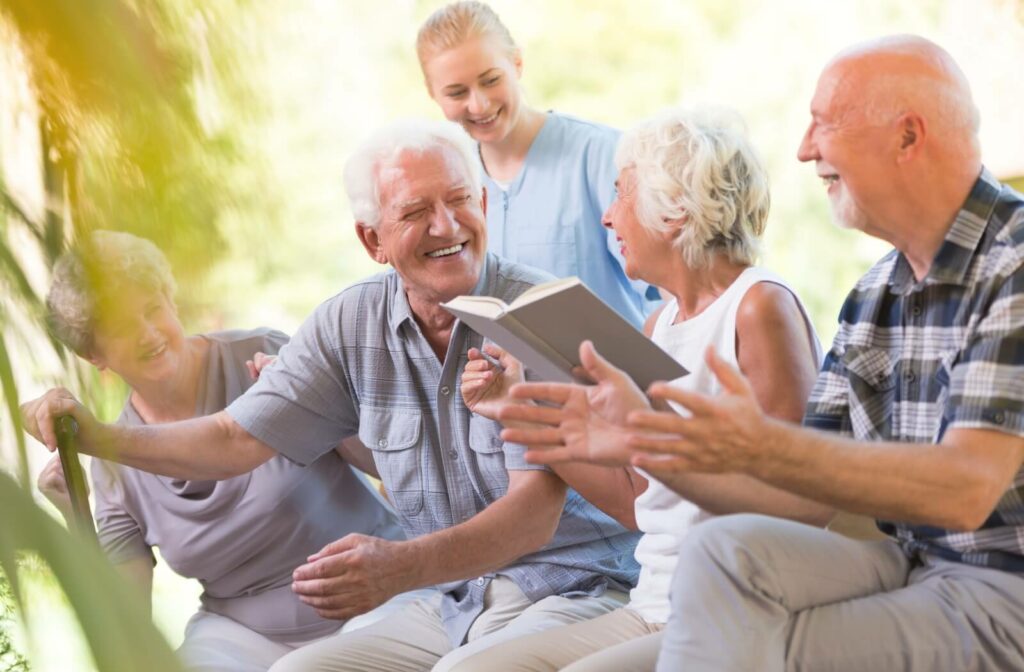 A group of residents in assisted living spending time outdoors, smiling and having fun in a sunlit garden.