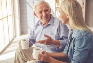 An adult child asks their parent thoughtful and engaging questions while visiting them in assisted living.